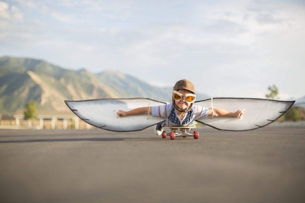 Young Boy Flying on Skateboard with Wings