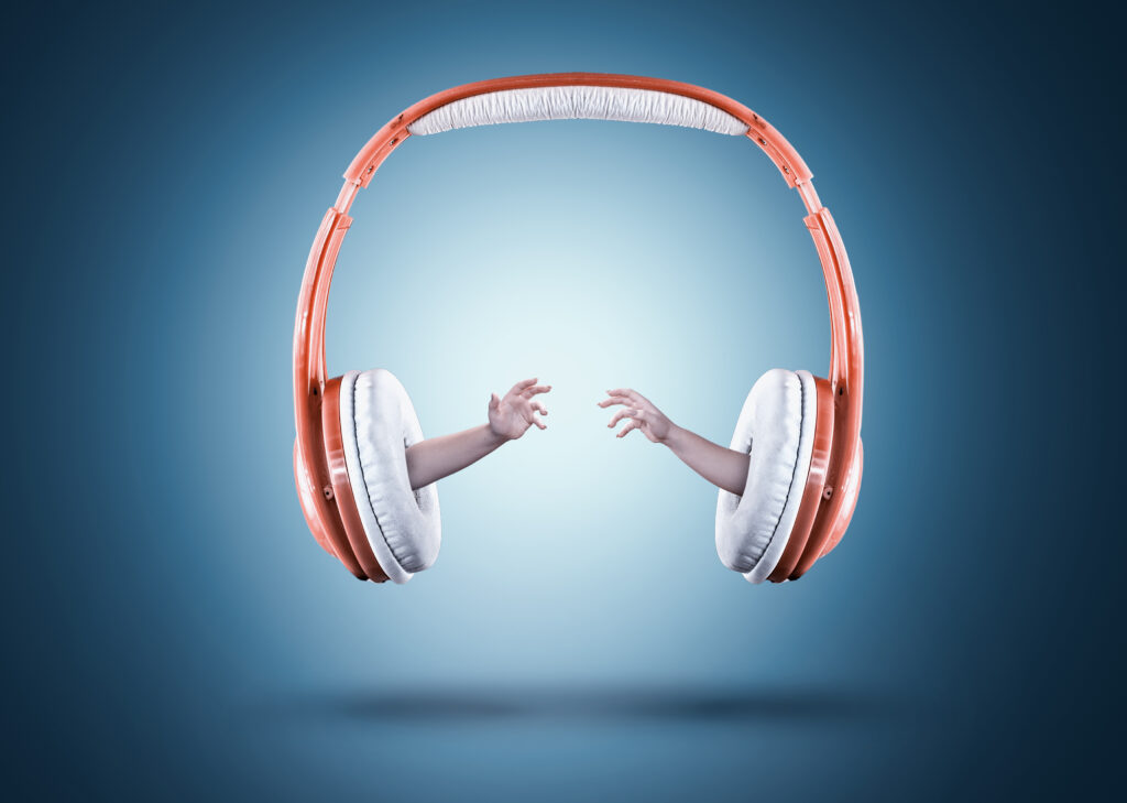 Hands reaching out of headphones.