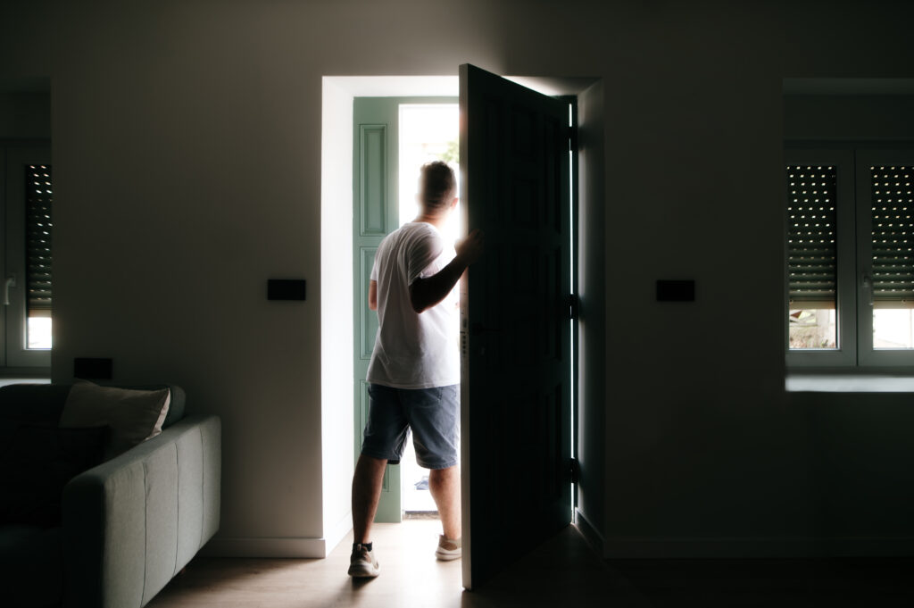 Man walking out the door of the house